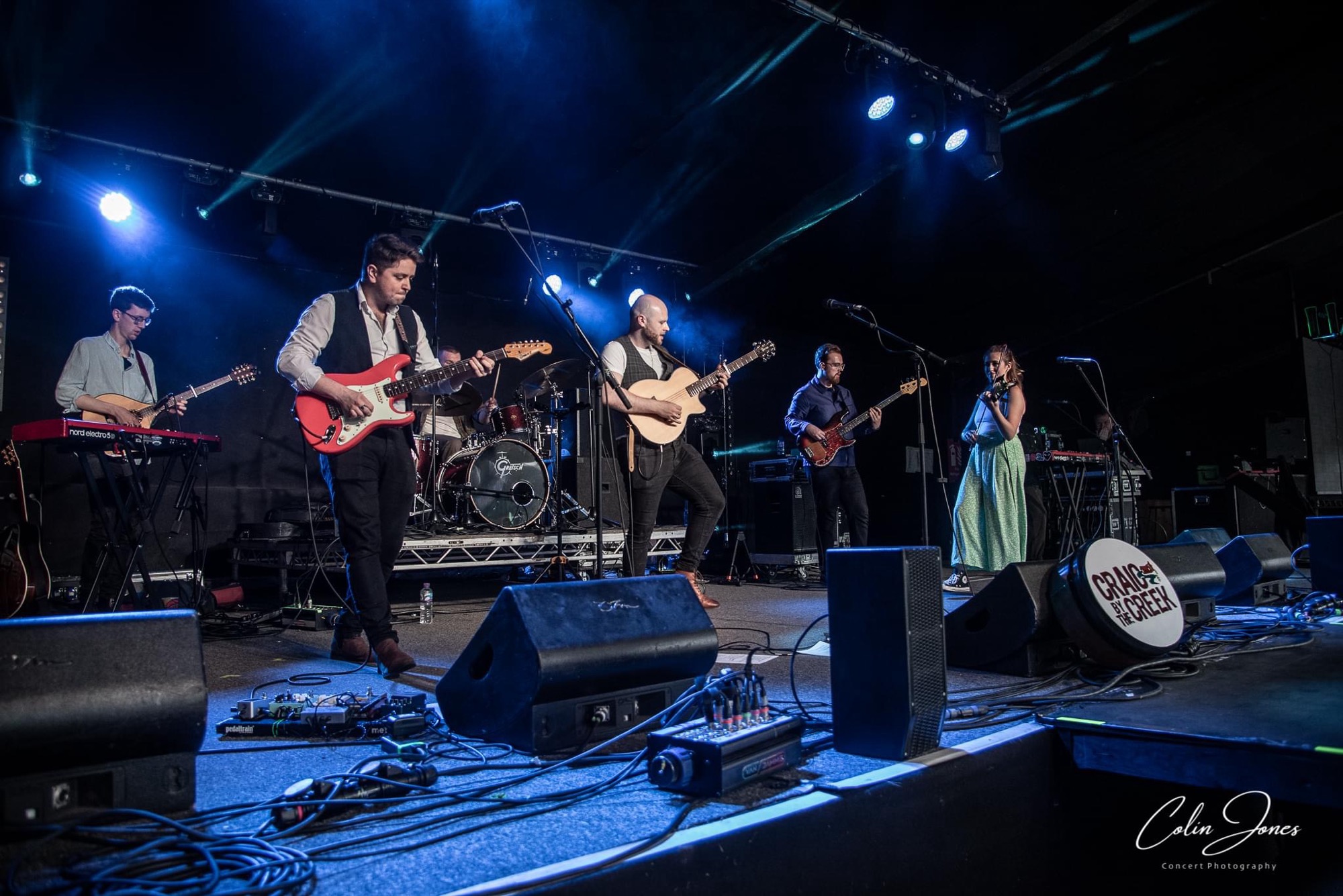 The full line-up on stage, with fiddle